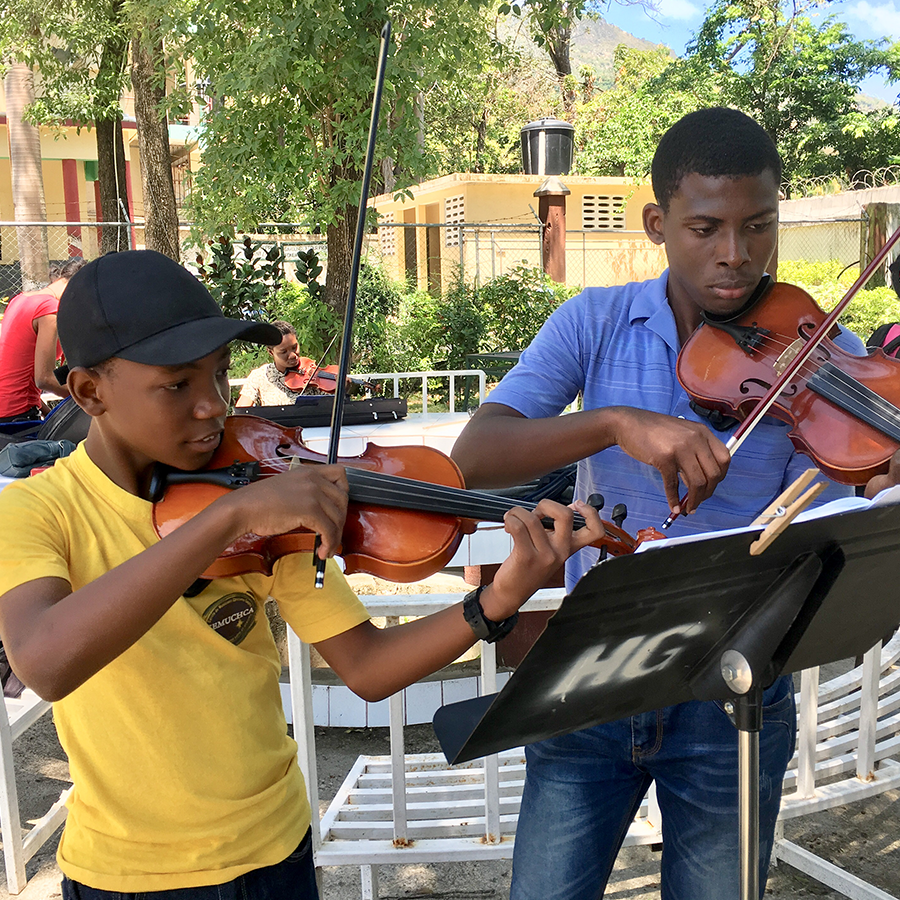 Two Haitian violinists practicing