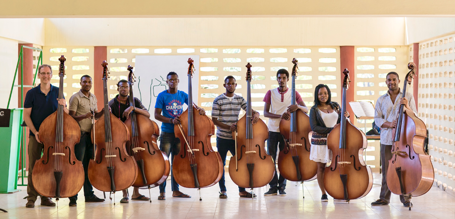 Thomas Sperl stands with 8 Haitian bassists